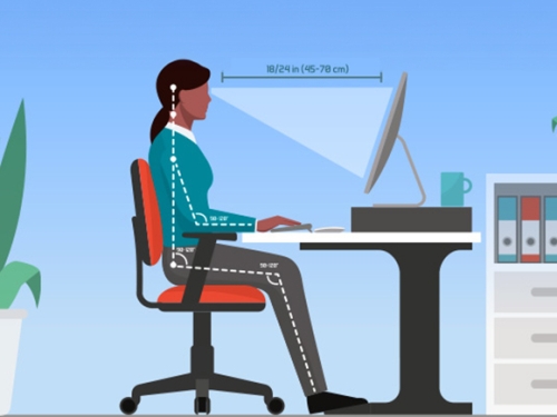 An individual sitting ergonomically at a work desk, facing a desktop computer, suggests a comfortable and productive workspace.
