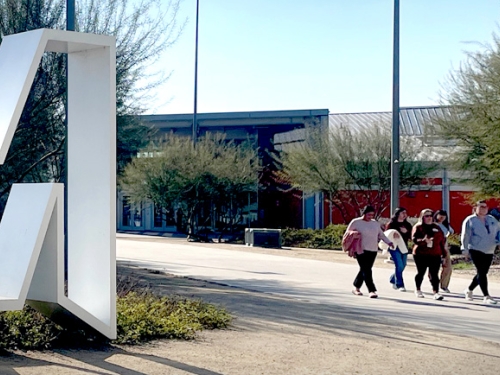 UC Merced "M" statue with unidentifiable students walking in the background on campus
